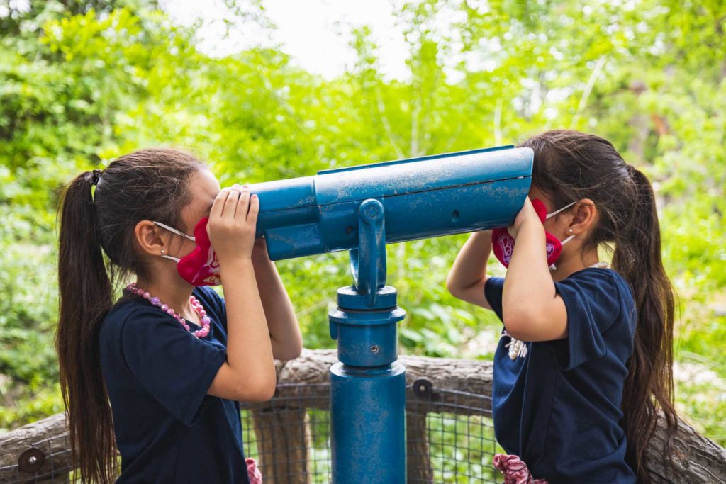 Kids looking through both ends of telescope