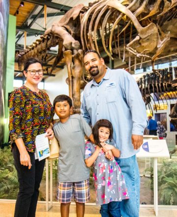 family in front of the dinosaurs