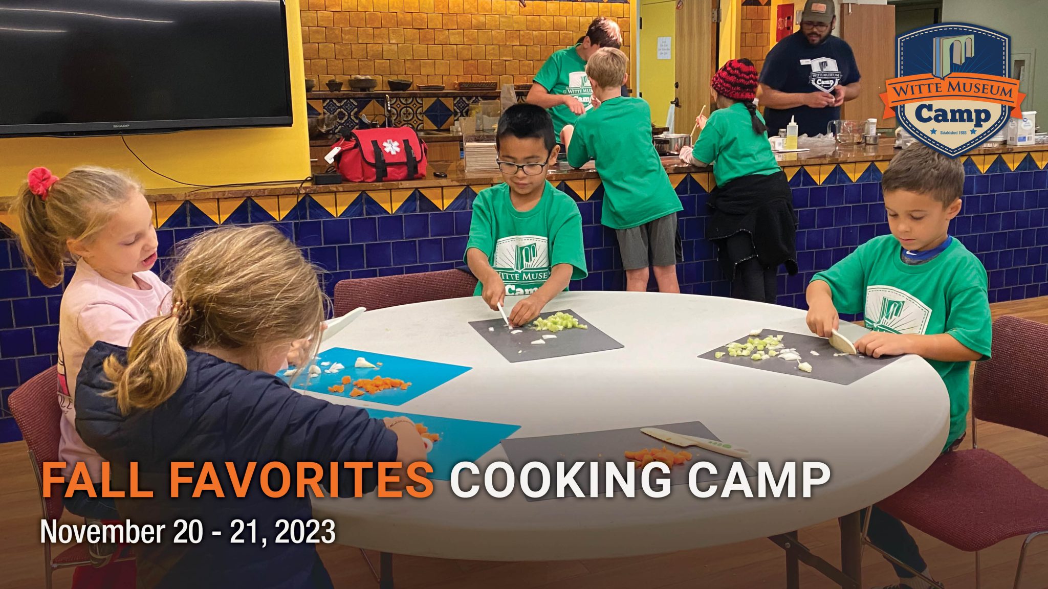 campers chop vegetables around a table.