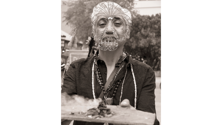 man holds tray while wearing a mask.