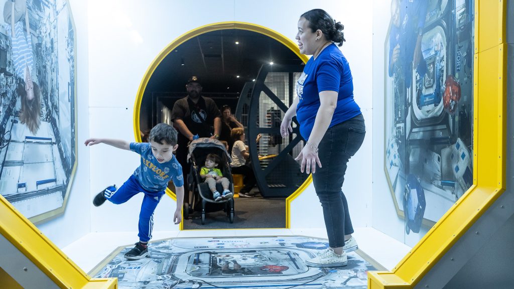 mother and son stand inside 'space lab'