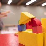 young child builds fort with blocks.